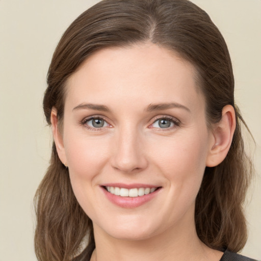 Joyful white young-adult female with medium  brown hair and grey eyes