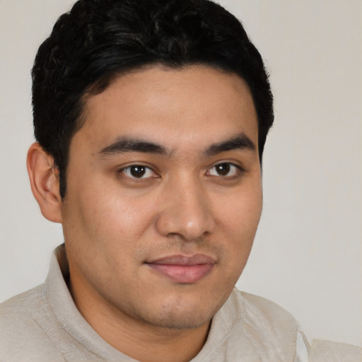 Joyful latino young-adult male with short  brown hair and brown eyes