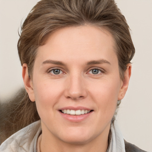 Joyful white young-adult female with short  brown hair and grey eyes