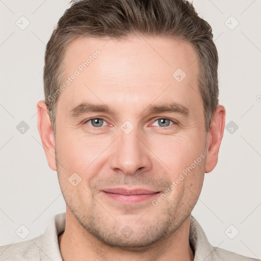 Joyful white young-adult male with short  brown hair and grey eyes