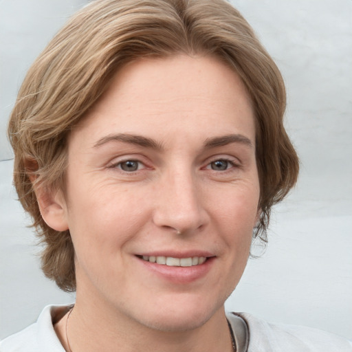 Joyful white adult female with short  brown hair and blue eyes