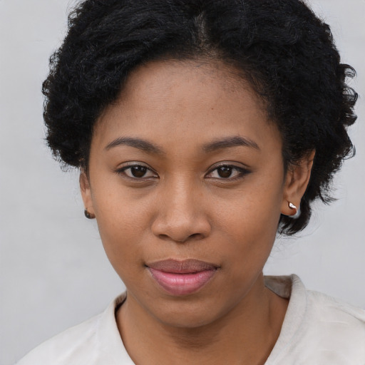 Joyful black young-adult female with short  black hair and brown eyes