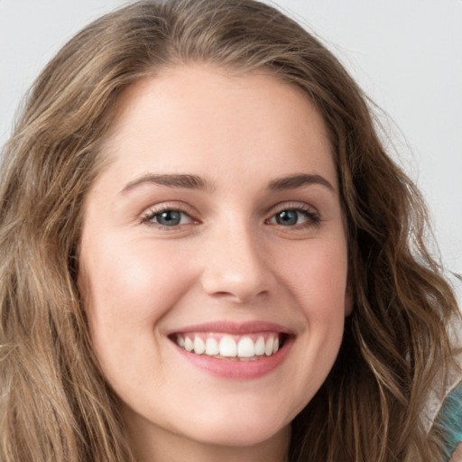 Joyful white young-adult female with long  brown hair and green eyes