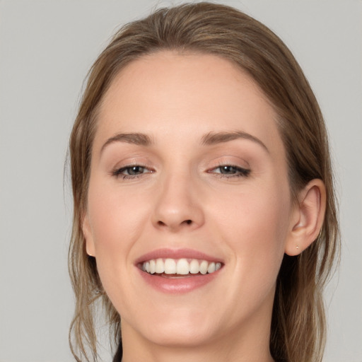 Joyful white young-adult female with medium  brown hair and grey eyes