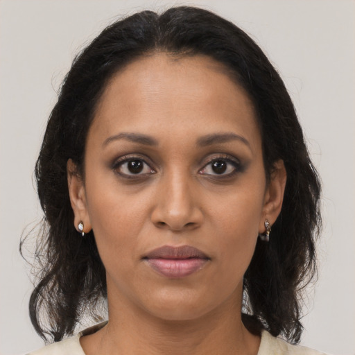 Joyful black adult female with medium  brown hair and brown eyes