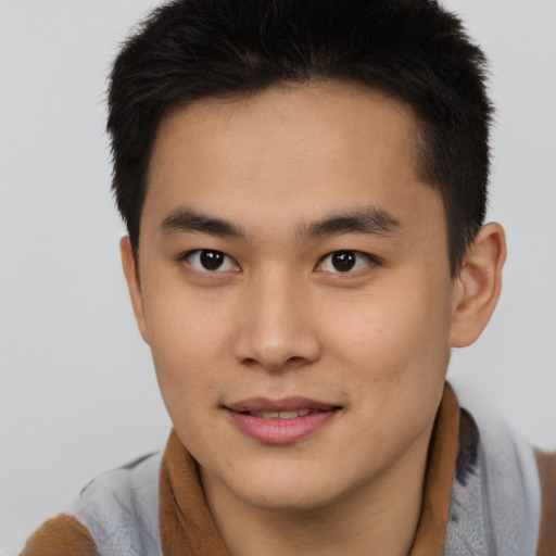 Joyful asian young-adult male with short  brown hair and brown eyes