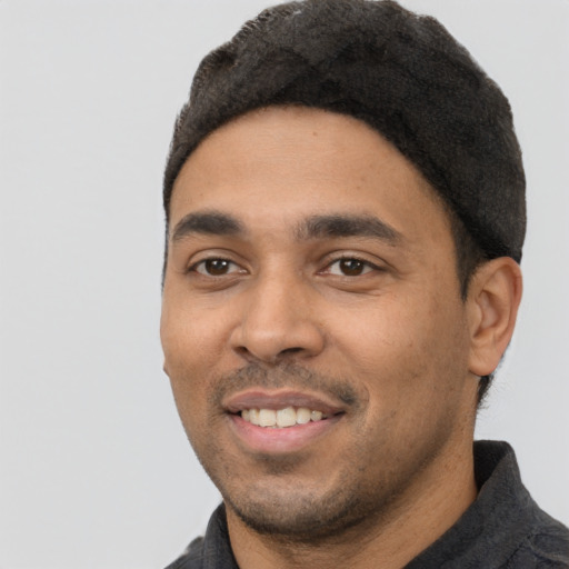 Joyful latino young-adult male with short  black hair and brown eyes