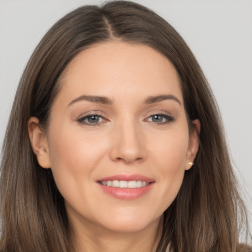 Joyful white young-adult female with long  brown hair and brown eyes