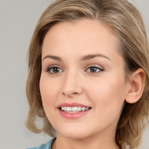 Joyful white young-adult female with long  brown hair and blue eyes