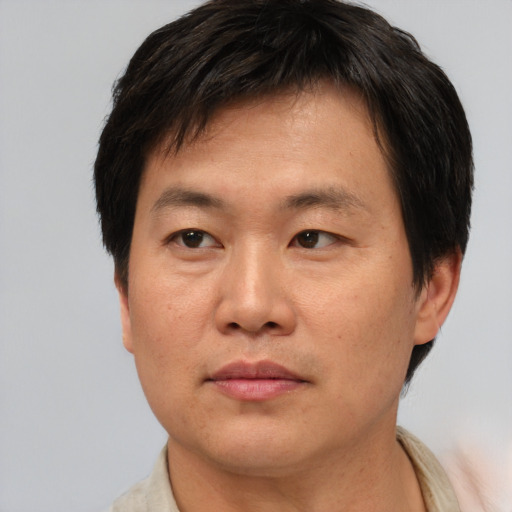 Joyful asian adult male with short  brown hair and brown eyes