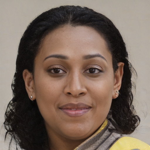 Joyful black young-adult female with long  brown hair and brown eyes