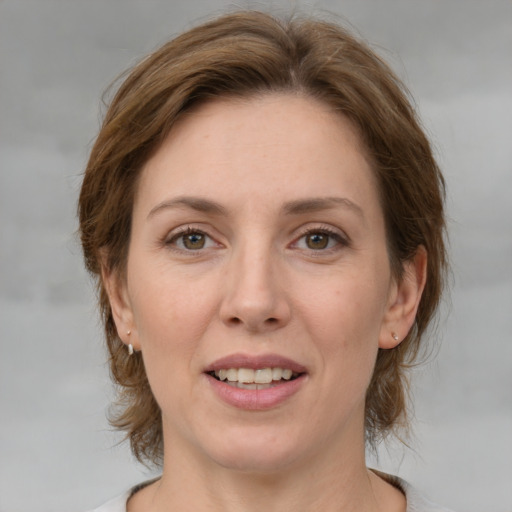 Joyful white adult female with medium  brown hair and green eyes