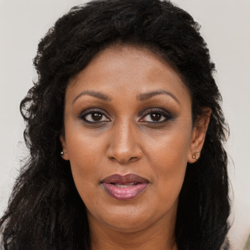 Joyful black adult female with long  brown hair and brown eyes