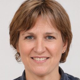 Joyful white adult female with medium  brown hair and grey eyes