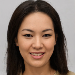 Joyful asian young-adult female with long  brown hair and brown eyes