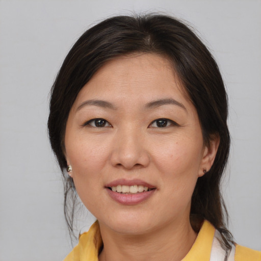 Joyful asian young-adult female with medium  brown hair and brown eyes
