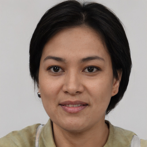 Joyful white adult female with medium  black hair and brown eyes