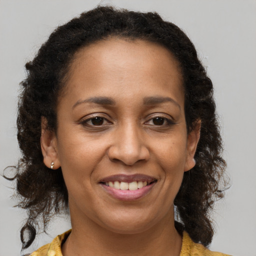 Joyful black adult female with medium  brown hair and brown eyes