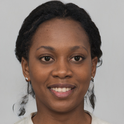 Joyful black young-adult female with short  black hair and brown eyes