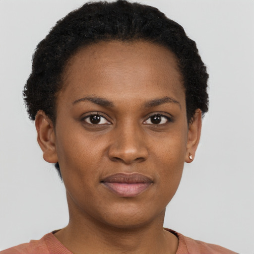 Joyful black young-adult female with short  black hair and brown eyes