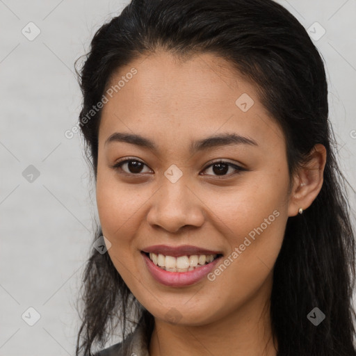 Joyful latino young-adult female with long  brown hair and brown eyes