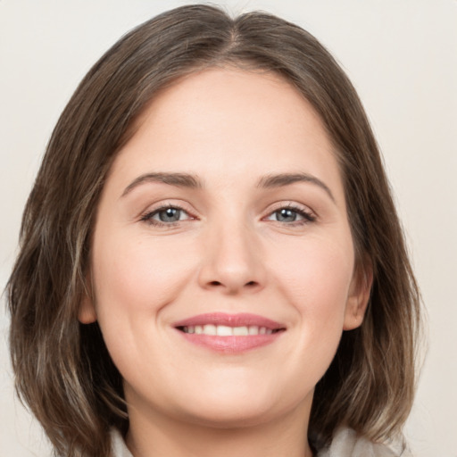 Joyful white young-adult female with medium  brown hair and grey eyes