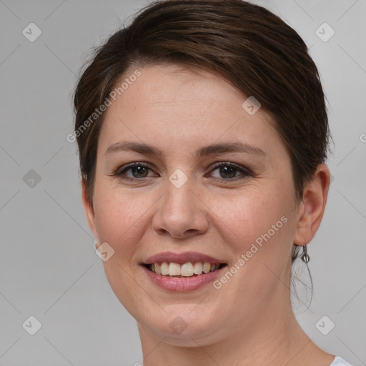 Joyful white young-adult female with short  brown hair and grey eyes