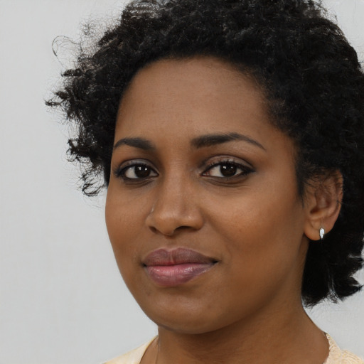 Joyful black young-adult female with short  black hair and brown eyes