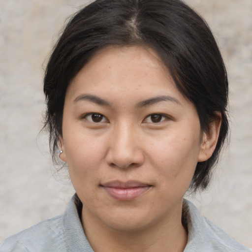 Joyful asian adult female with medium  brown hair and brown eyes