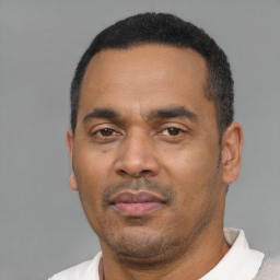 Neutral latino adult male with short  black hair and brown eyes