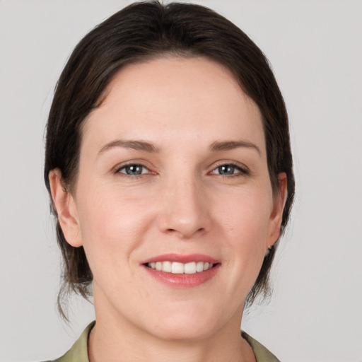 Joyful white young-adult female with medium  brown hair and grey eyes