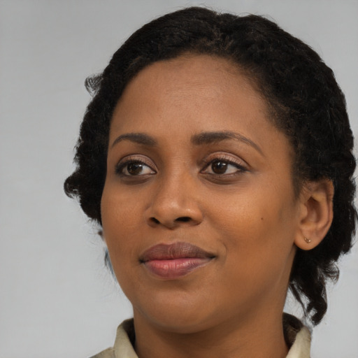Joyful black young-adult female with medium  black hair and brown eyes