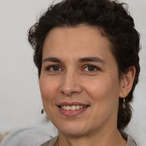 Joyful white adult female with medium  brown hair and brown eyes