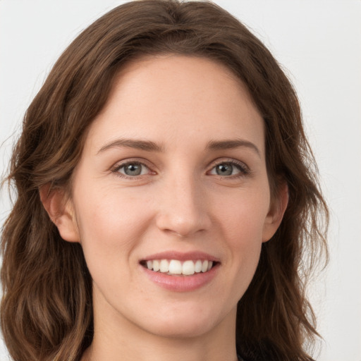 Joyful white young-adult female with long  brown hair and grey eyes