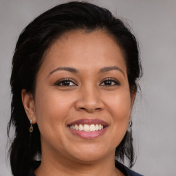 Joyful latino young-adult female with medium  brown hair and brown eyes