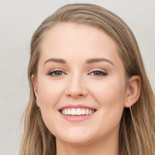 Joyful white young-adult female with long  brown hair and grey eyes