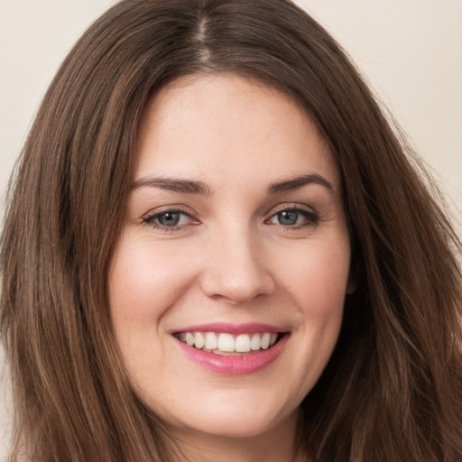 Joyful white young-adult female with long  brown hair and green eyes