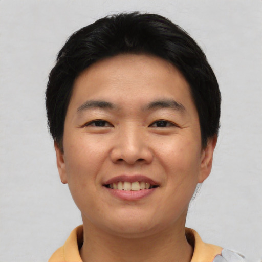 Joyful asian young-adult male with short  black hair and brown eyes