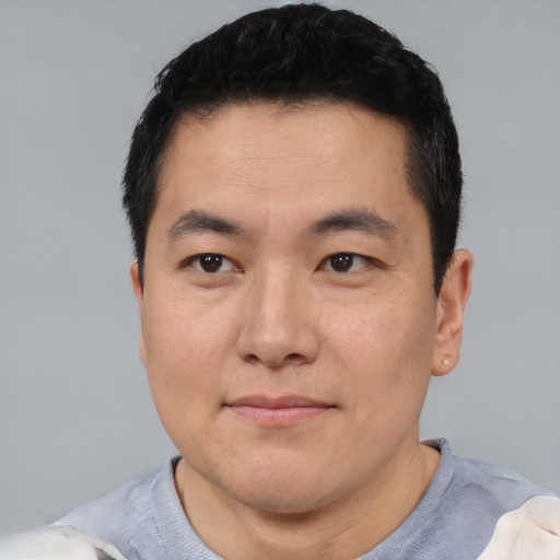 Joyful asian young-adult male with short  black hair and brown eyes