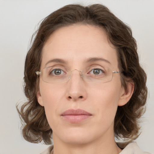 Joyful white adult female with medium  brown hair and green eyes