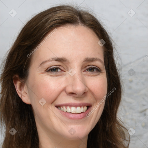 Joyful white adult female with long  brown hair and grey eyes