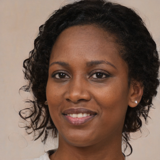 Joyful black young-adult female with medium  brown hair and brown eyes