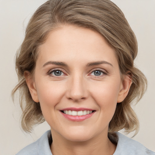 Joyful white young-adult female with medium  brown hair and grey eyes