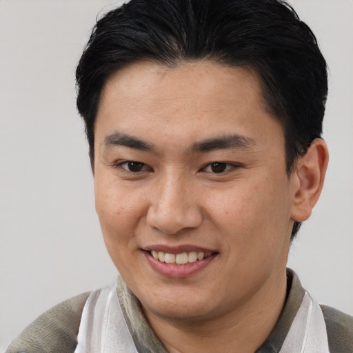 Joyful asian young-adult male with short  brown hair and brown eyes