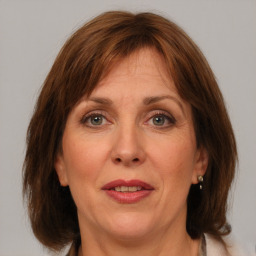 Joyful white adult female with medium  brown hair and grey eyes