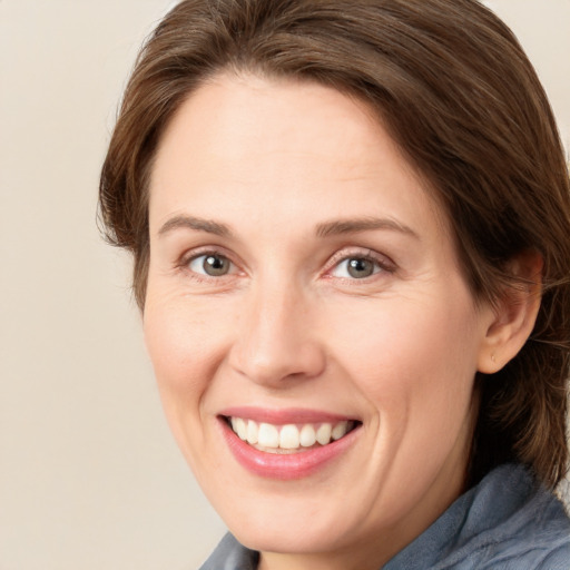 Joyful white adult female with medium  brown hair and blue eyes