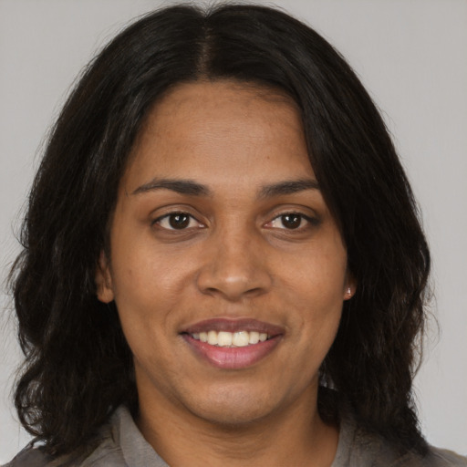 Joyful black young-adult female with medium  brown hair and brown eyes
