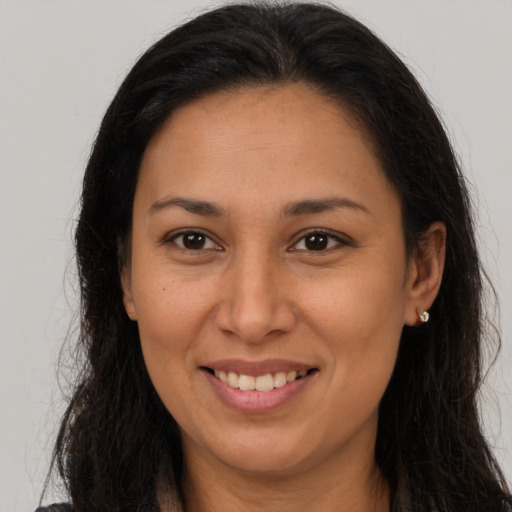 Joyful latino young-adult female with long  brown hair and brown eyes