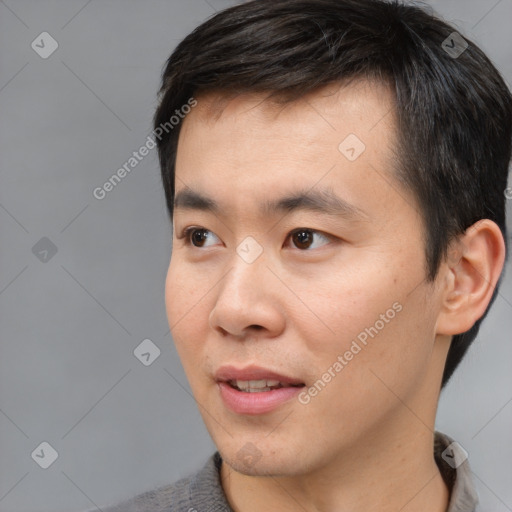 Joyful asian young-adult male with short  black hair and brown eyes