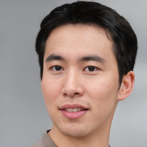 Joyful asian young-adult male with short  black hair and brown eyes
